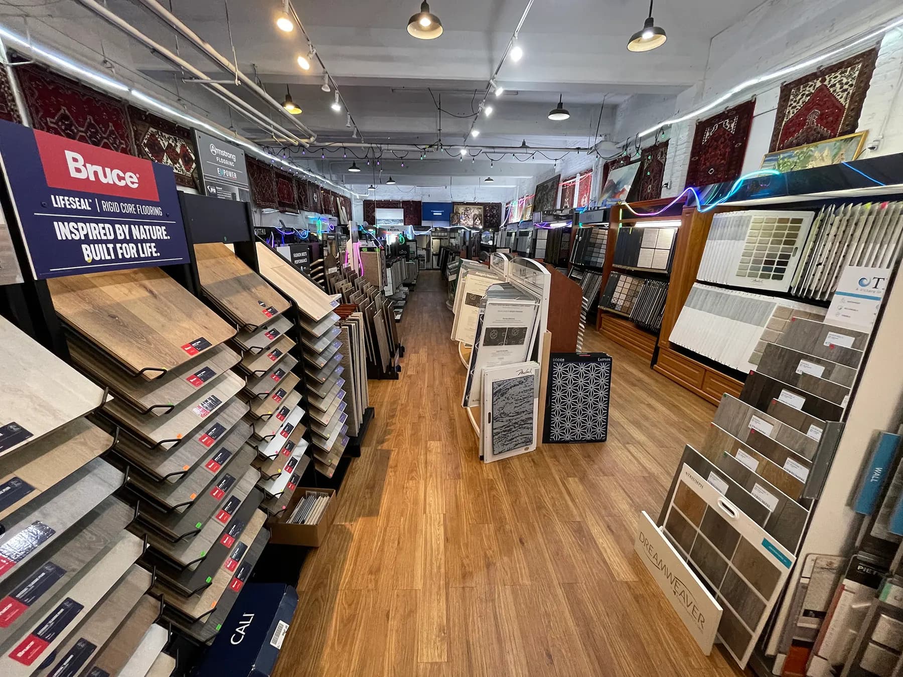Wide view of the Capital Carpet showroom with sample racks and rugs on the walls